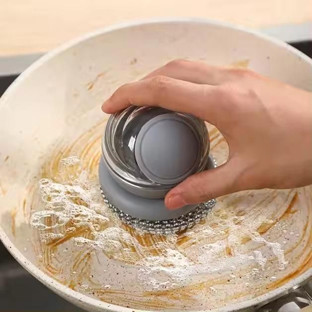Hand cleaning a pan with a modern automatic soap dispenser scrubber in use