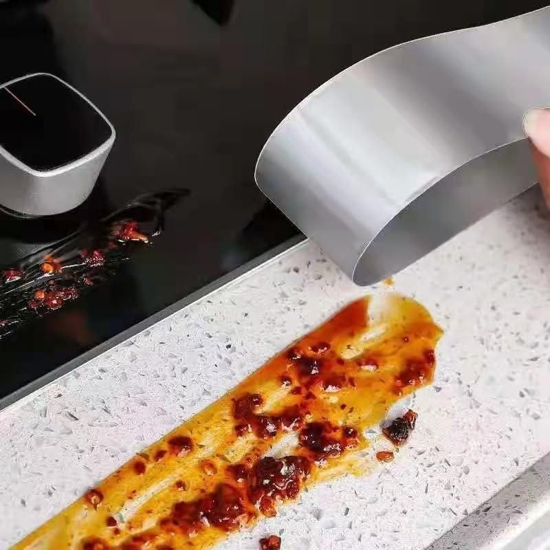 Silver fireproof adhesive tape for kitchen applied near stove with spilled sauce on countertop